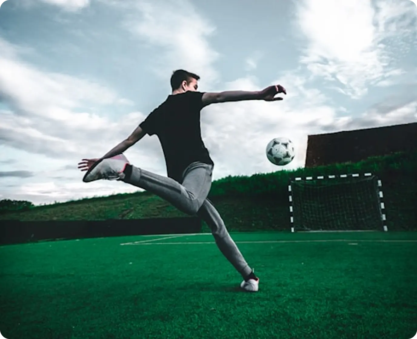 Soccer player's legs with ball on turf field 